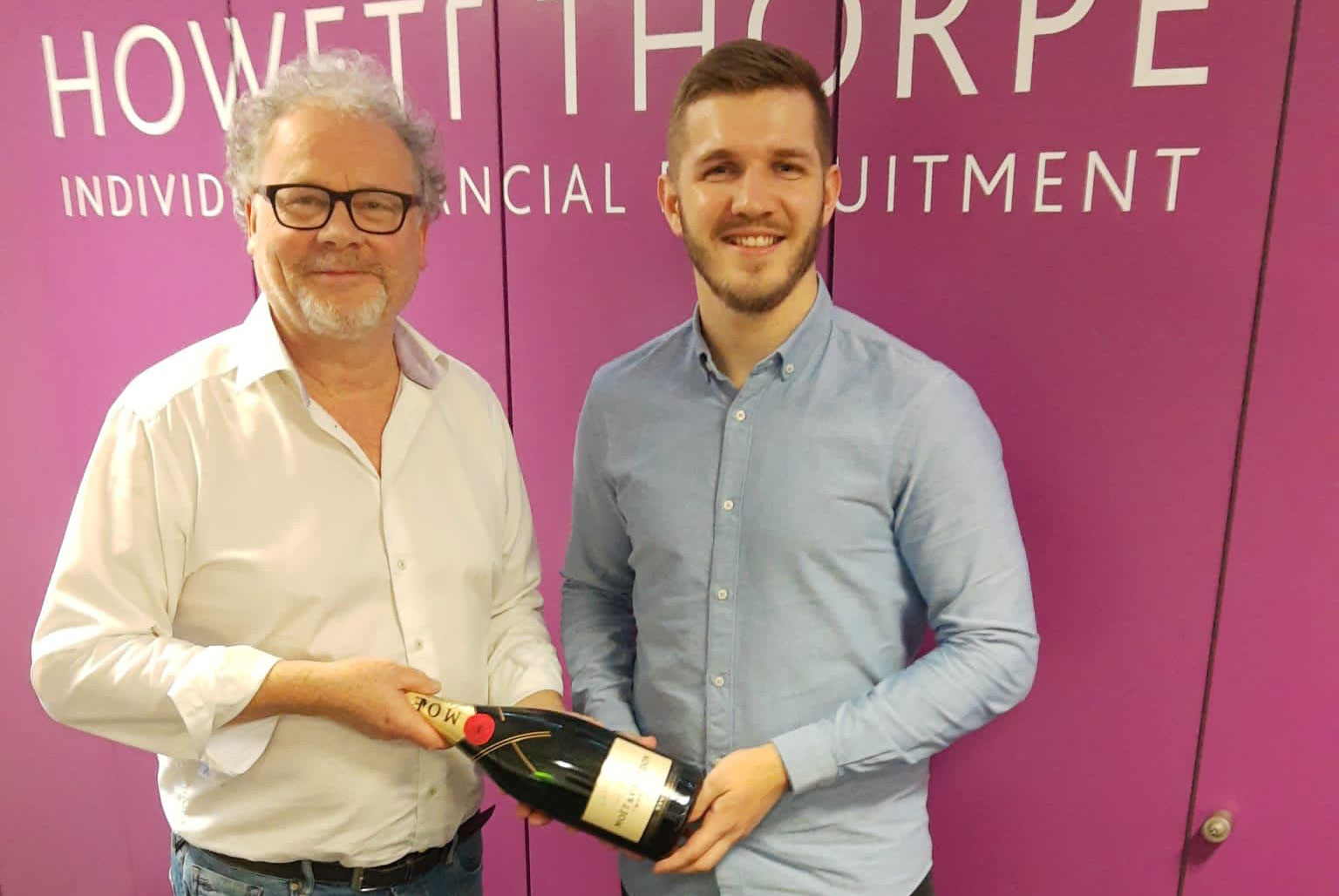 Business professionals presenting employee recognition award in office setting