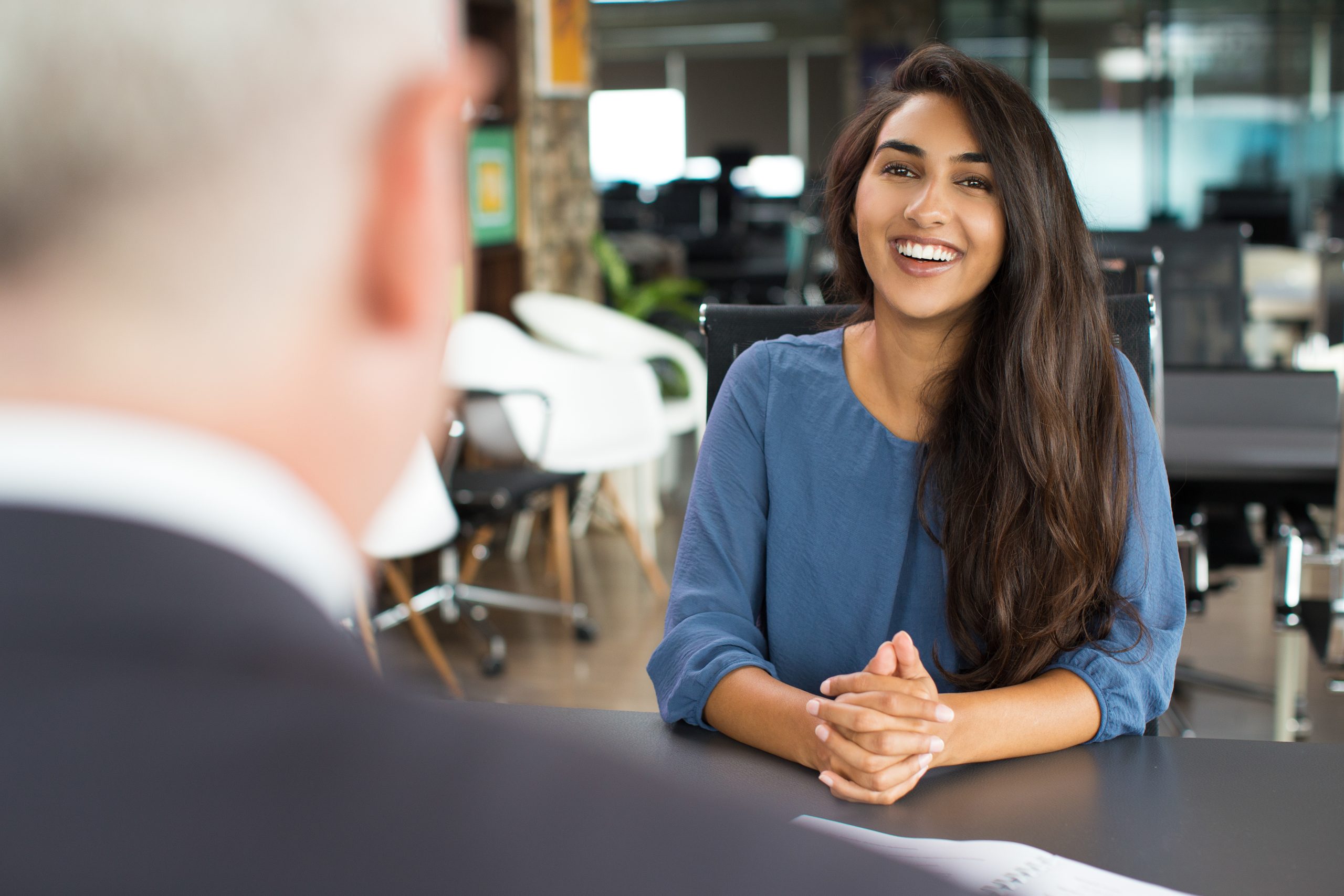 Candidate smiling during job interview with recruitment consultant in office