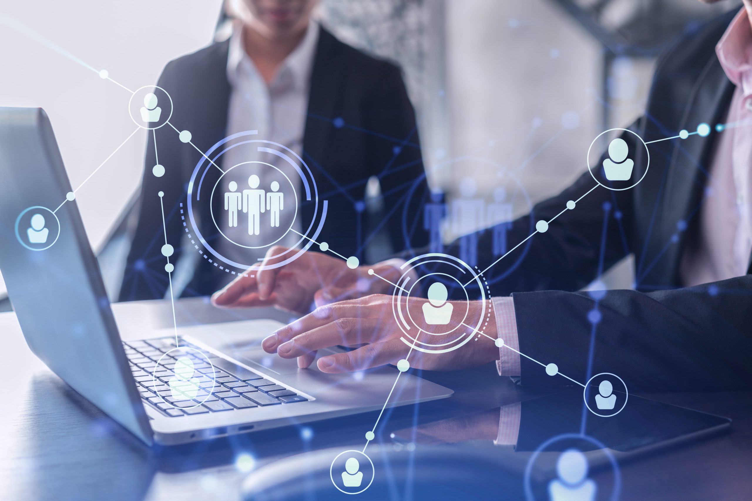 Automation in Recruitment: Two professionals collaborate on a laptop, surrounded by a network graphic.