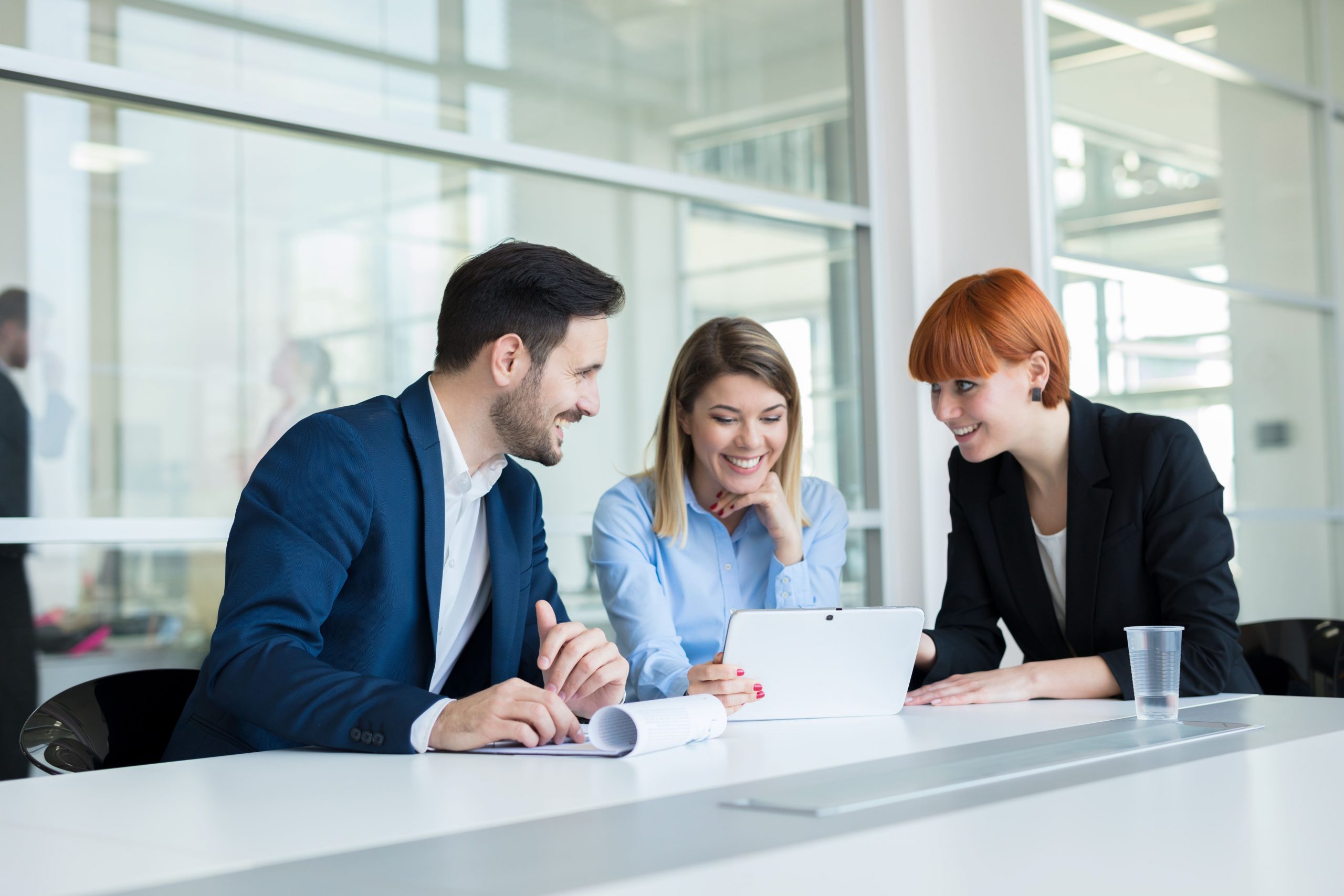 A women helping a man and another women with data on a tablet showing how support roles are changing